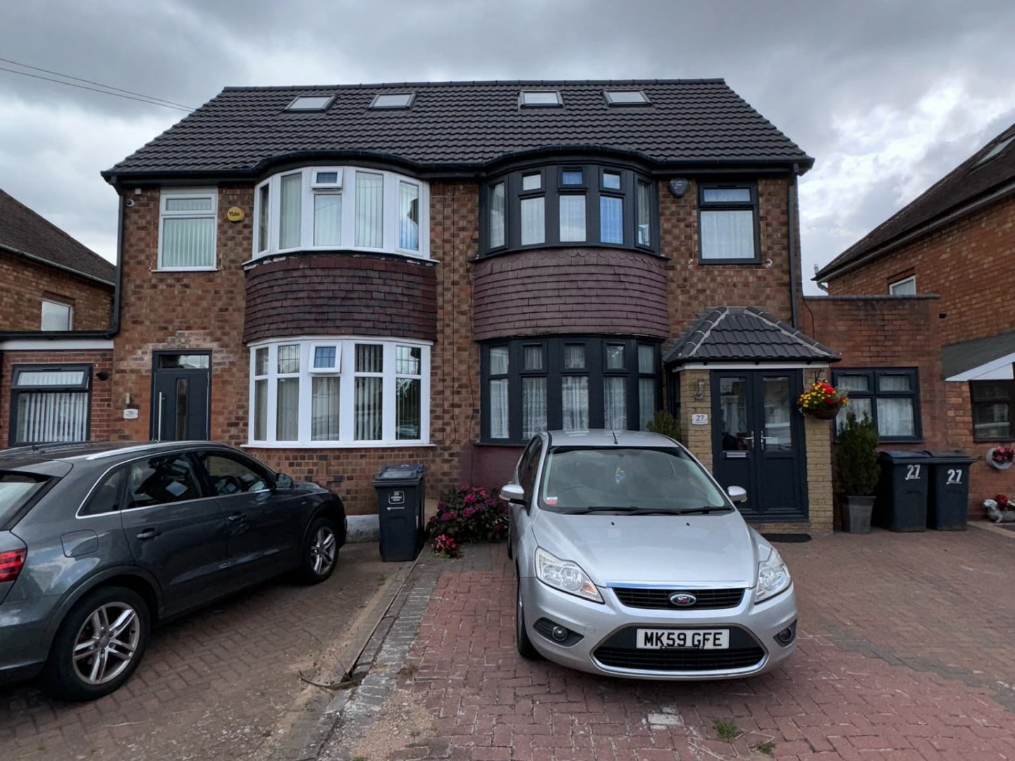 Red brick semi-detached house with tile-hung bays before external wall insulation