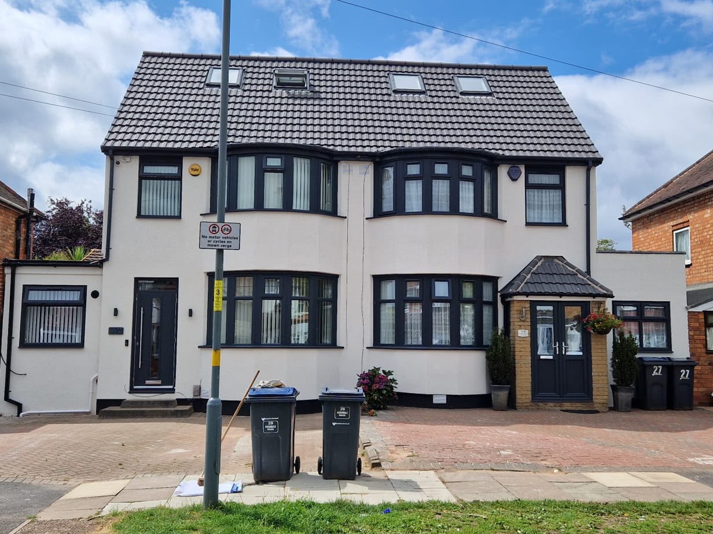 Rendered semi, Birmingham — Red brick semi wrapped in external wall insulation and finished in a smooth off-white through-coloured render with dark grey trims.